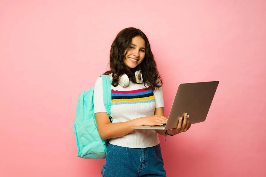 Estudiante posando con su portátil abierto