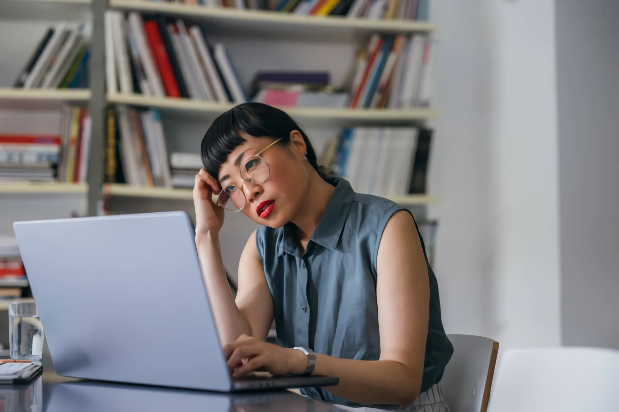 Mujer pensando frente a su computador