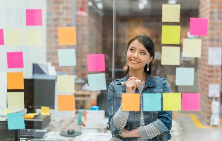 Mujer mirando sus anotaciones en un tablero