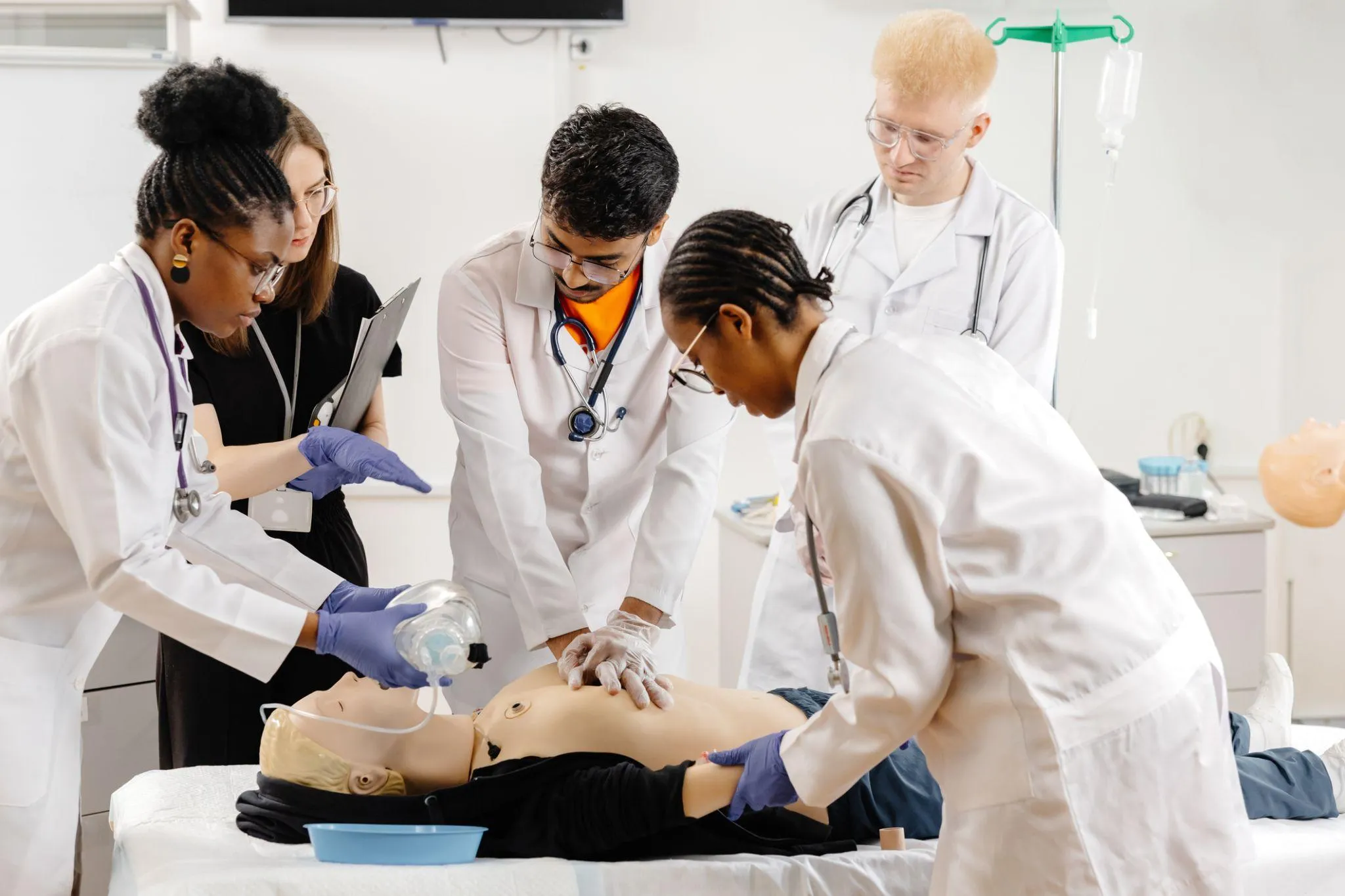Estudiantes practicando reanimación cardiopulmonar en un simulador