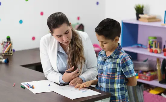 Docente con un niño en clase