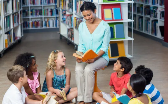 Maestra leyendo a niños en la biblioteca